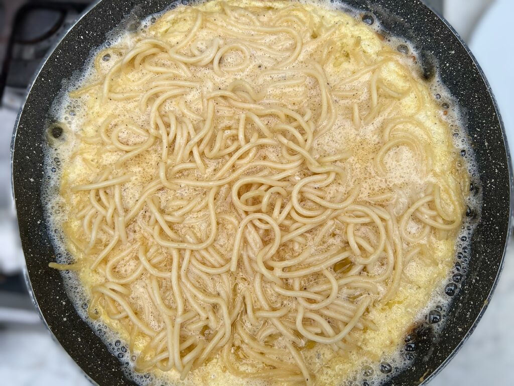 Spaghetti frittata being cooked for a recipe from the Puglia Kitchen by the Puglia Guys. 