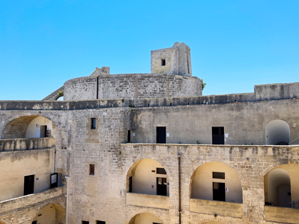 Castle of Otranto (Castello Aragonese)

This formidable structure was initiated after the 1481 reconquest of Otranto by the Aragonese. Spanish viceroys, particularly Toledo, fortified it further by adding external bastions to enhance the city's defenses and adapt to evolving offensive techniques. The castle boasts a pentagonal design, featuring three circular towers at three of its corners, while the northeastern corner is reinforced with a sharp spur extending toward the port. The entrance is surmounted by Charles V's imperial coat of arms, and within, a courtyard leads to a gallery on the upper floor, offering access to various rooms.

Originally a Swabian fortification, one of the towers within the structure of the Castello Aragonese was built under the supervision of Duke Alfonso of Aragon, following the city’s reconquest following Turkish occupation. Later, in the 16th century, Spanish viceroys further fortified Salento's centres due to ongoing pirate incursions (a new Turkish landing near Otranto occurred in 1537). Enhancements by the Venetians added artillery and bombards.

The castle inspired Horace Walpole’s 1764 gothic novel The Castle of Otranto and Voltaire’s 1769 comic opera Le Baron d’Otrante. 

Today, the fortress serves as a cultural center hosting art exhibitions and events. Entrance fee €12 (check website for current pricing).

Photo by the Puglia Guys, Puglia ambassadors. PugliaGuys.com