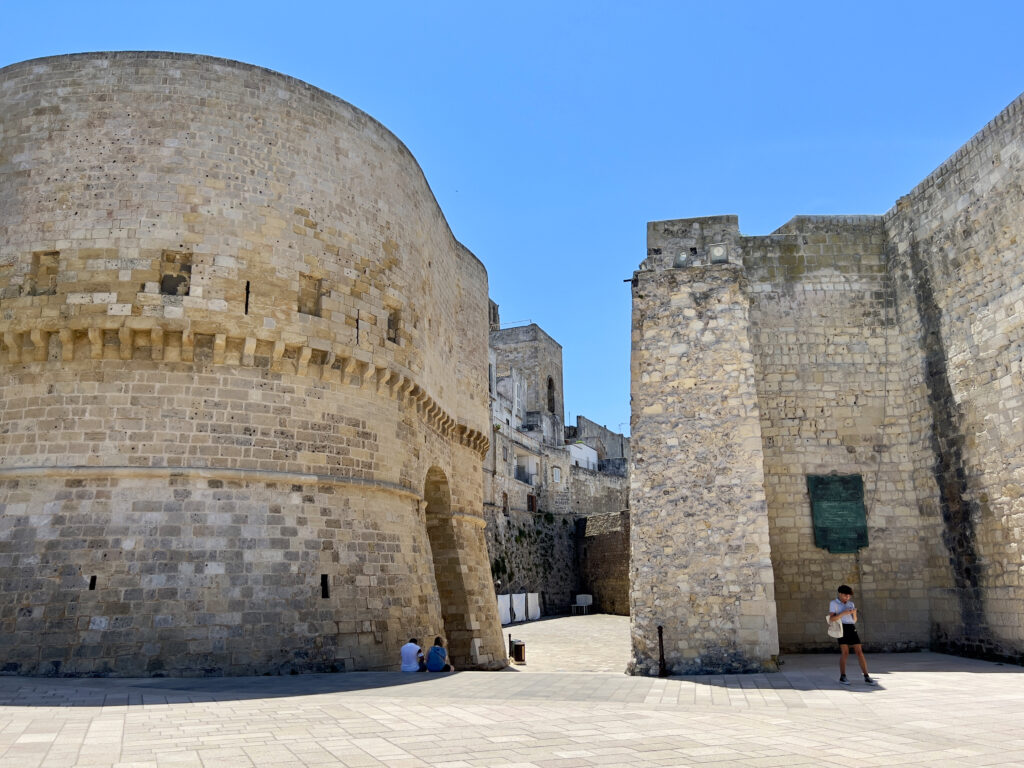 Land Gate (Porta Alfonsina) and Old Town

The present-day fortifications of Otranto can be attributed to two phases. The Land Gate and the Aragonese Castle. 

Following the reconquest of Otranto ending Turk occupation, the Aragonese constructed new defences including the Porta Alfonsina outer gate to the old town with its two side towers. From here wander through into the historic center of Otranto. Stroll along the narrow streets, lined with white-washed buildings and local shops, and immerse yourself in Otranto’s history.

Photo by the Puglia Guys, Puglia ambassadors. PugliaGuys.com