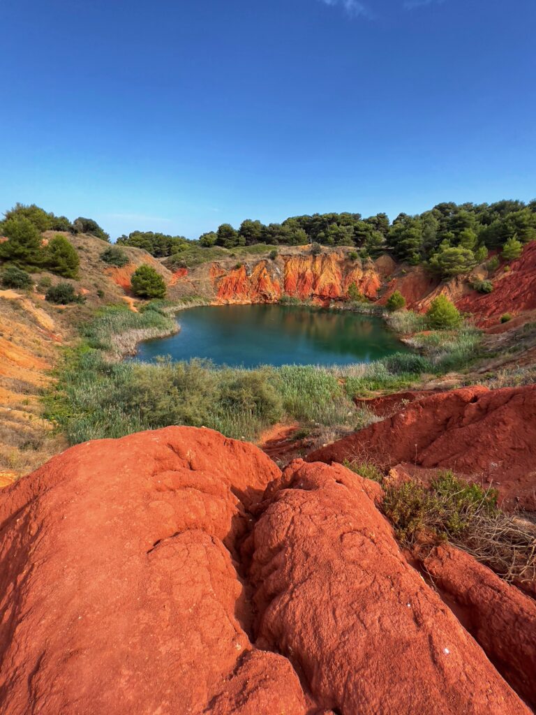 Heading south, take a short drive from Otranto to explore the surreal Bauxite Cave, a former bauxite mine known for its emerald-green waters and unique landscape. It's a great spot for hiking and photography. There is a parking lot nearby (3€) and from there it’s a 10 minute walk to the lake. There is a small van selling refreshments half way along!

Photo by the PugliaGuys, Puglia ambassadors. PugliaGuys.com